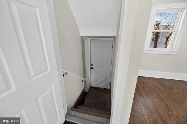 a view of a hallway with wooden floor and entryway