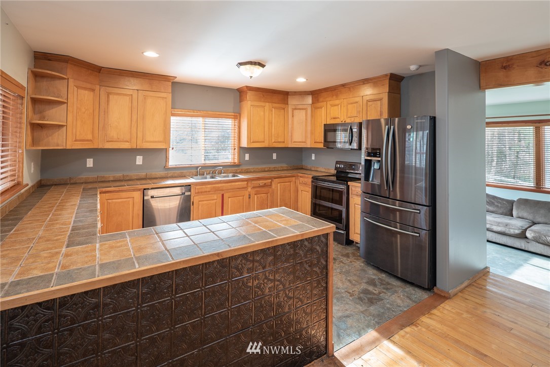 3399 East Harbor Road Langley, WA 98260 - Photo 20 of 36 a kitchen with stainless steel appliances granite countertop a sink stove and refrigerator