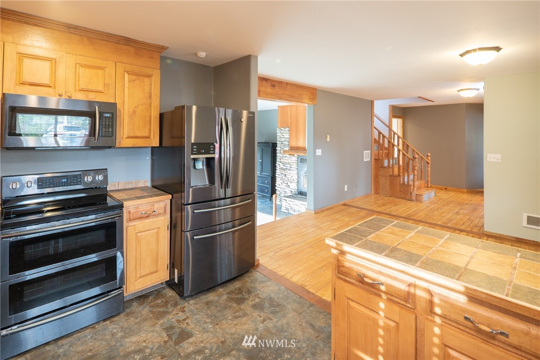 3399 East Harbor Road Langley, WA 98260 - Photo 22 of 36 a kitchen with stainless steel appliances granite countertop a refrigerator and a stove top oven