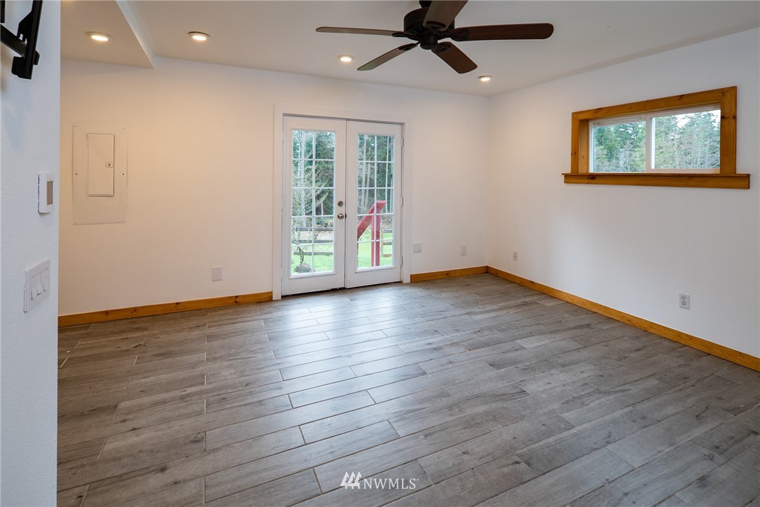 3399 East Harbor Road Langley, WA 98260 - Photo 27 of 36 an empty room with wooden floor fan and windows