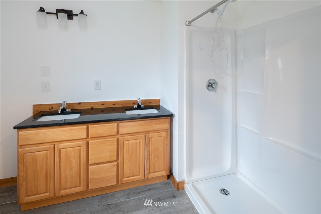 3399 East Harbor Road Langley, WA 98260 - Photo 28 of 36 a bathroom with a granite countertop sink and a mirror