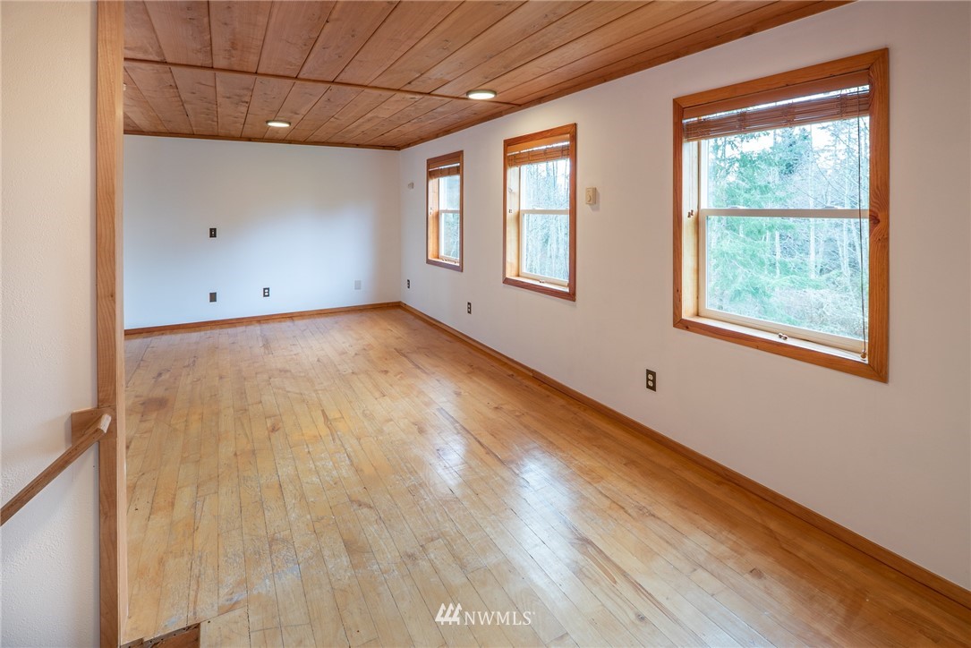 3399 East Harbor Road Langley, WA 98260 - Photo 30 of 36 an empty room with wooden floor and windows