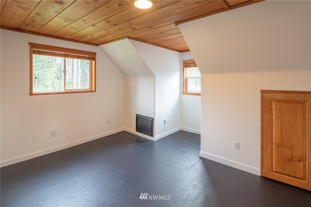 3399 East Harbor Road Langley, WA 98260 - Photo 33 of 36 an empty room with wooden floor and windows