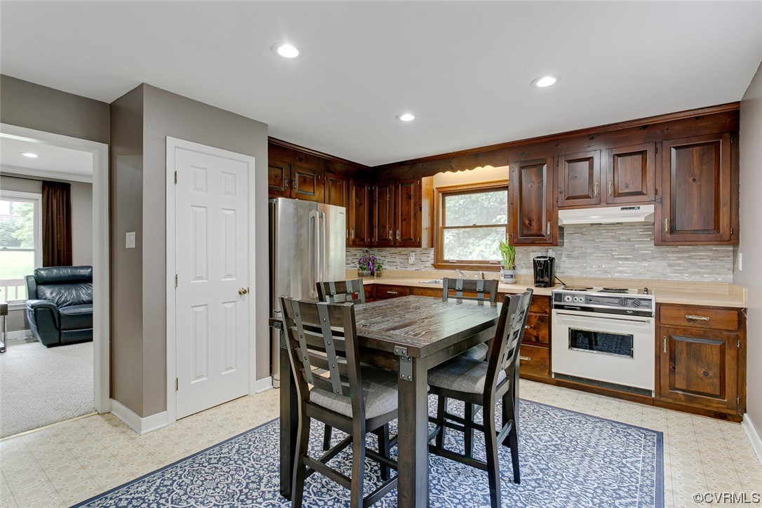 2125 Briarcliff Road Richmond, VA 23225 - Photo 5 of 27 Kitchen featuring dark brown cabinets, backsplash, range with electric cooktop, and light tile floors