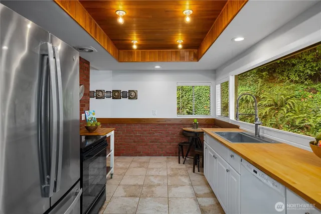 a kitchen with sink a window and stainless steel appliances