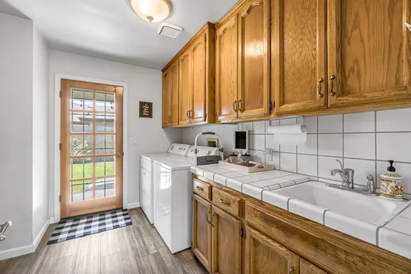 a kitchen with a sink a stove cabinets and wooden floor