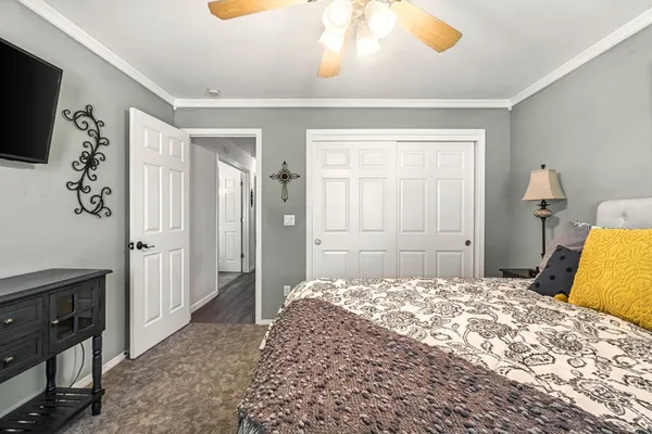 a bedroom with a bed and a flat tv screen on dresser