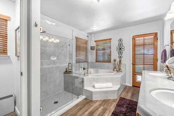 a bathroom with a bathtub shower sink vanity and toilet