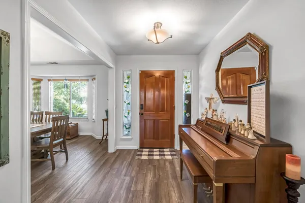 a view of a hallway to a livingroom with furniture and wooden floor