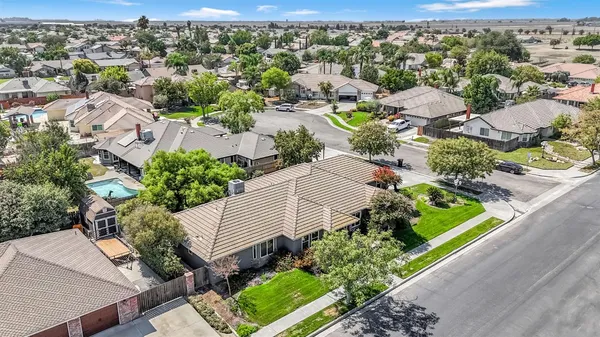 an aerial view of a house with a yard and mountain view in back