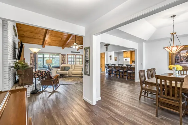 a view of a dining room and livingroom with furniture wooden floor a chandelier