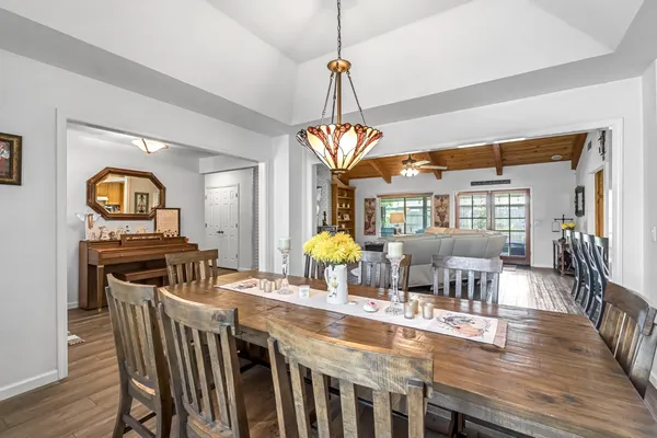 a dining room with furniture a chandelier and wooden floor