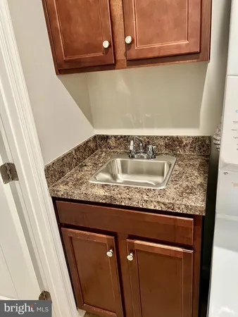 a utility room with granite countertop cabinets and utility