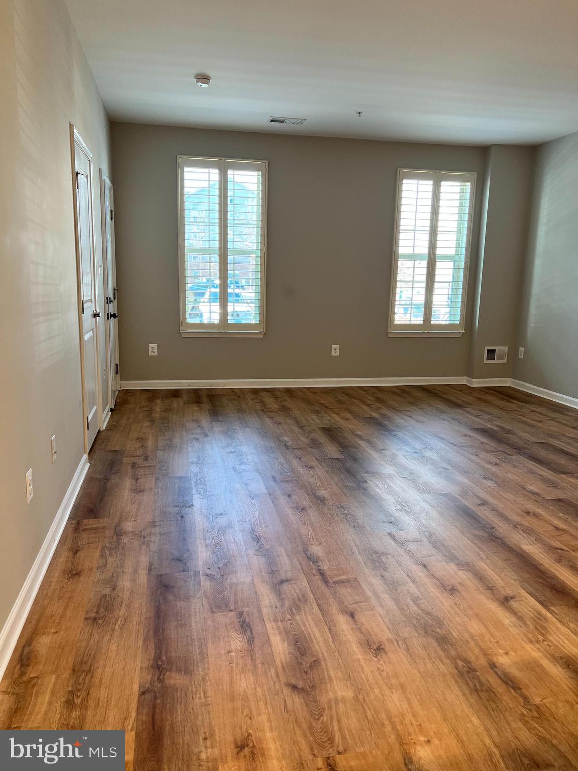 6508 Walcott Lane Frederick, MD 21703 - Photo 6 of 22 an empty room with wooden floor and windows