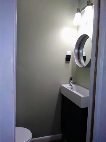 a bathroom with a toilet sink and mirror