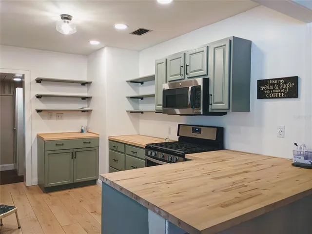 a kitchen with a refrigerator and a stove top oven