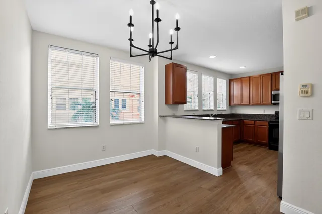 an empty room with wooden floor ceiling fan