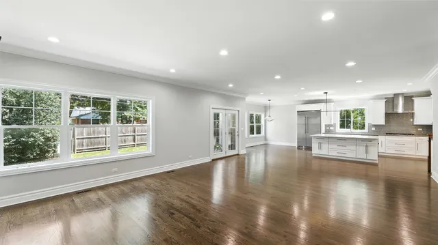 a view of empty room with wooden floor and a window