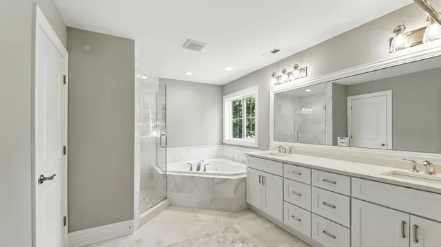 a spacious bathroom with a double vanity sink a mirror and a bathtub