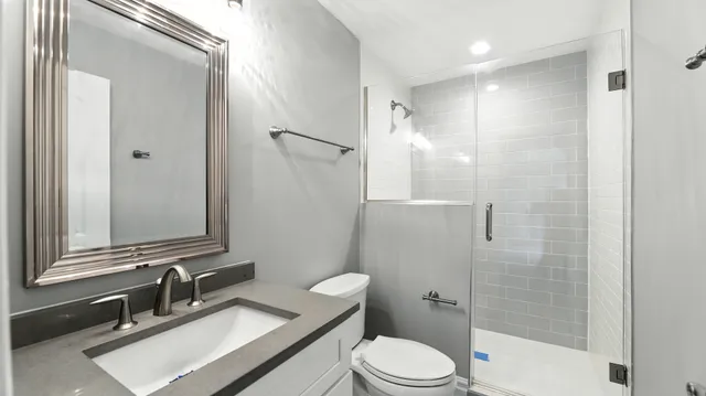 a bathroom with a sink a toilet and shower