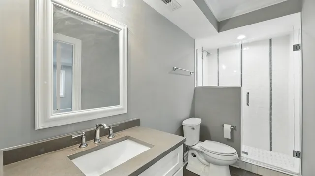 a bathroom with a granite countertop toilet sink and mirror