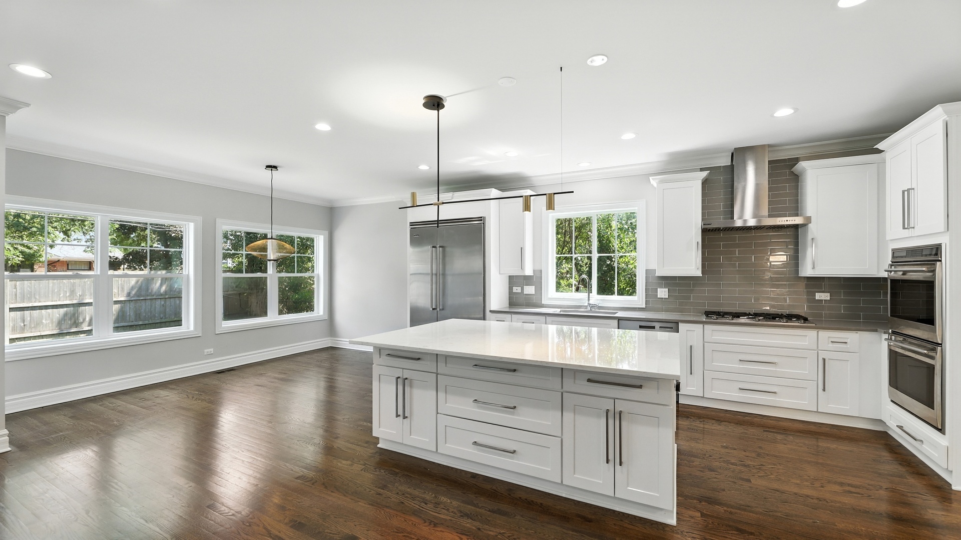 1127 Kenton Road Deerfield, IL 60015 - Photo 7 of 32 a kitchen with stainless steel appliances granite countertop a stove a sink and white cabinets with wooden floors