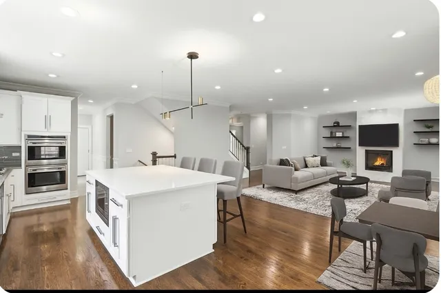 a large kitchen with stainless steel appliances kitchen island granite countertop a large kitchen island a stove a sink a dining table and chairs