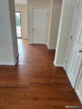 a view of a hallway with wooden floor and staircase