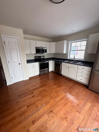 a kitchen with stainless steel appliances granite countertop a stove a sink and a refrigerator