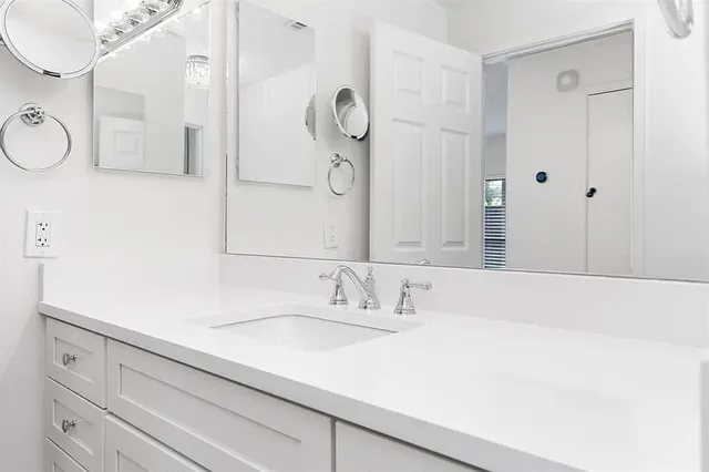 a bathroom with a sink vanity granite tub and shower