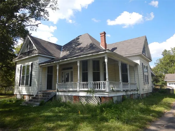 a backyard of a house with yard table and chairs