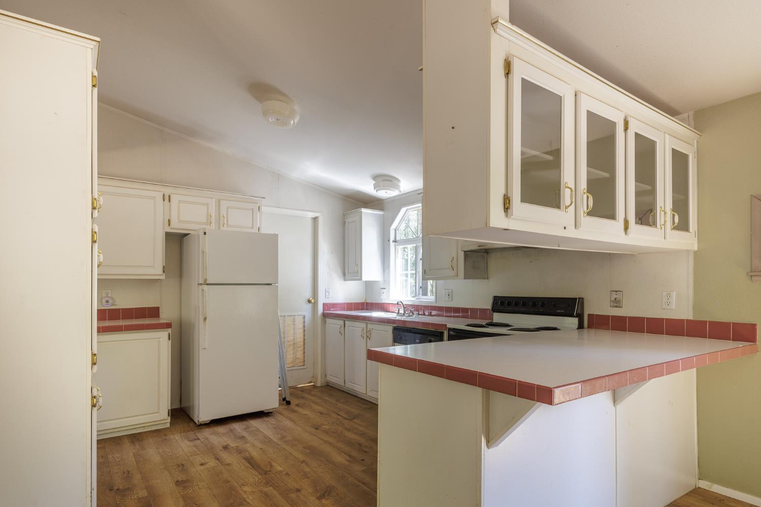 7140 Darling Cabin Road Garden Valley, CA 95633 - Photo 14 of 34 a kitchen with a refrigerator a stove a microwave and cabinets