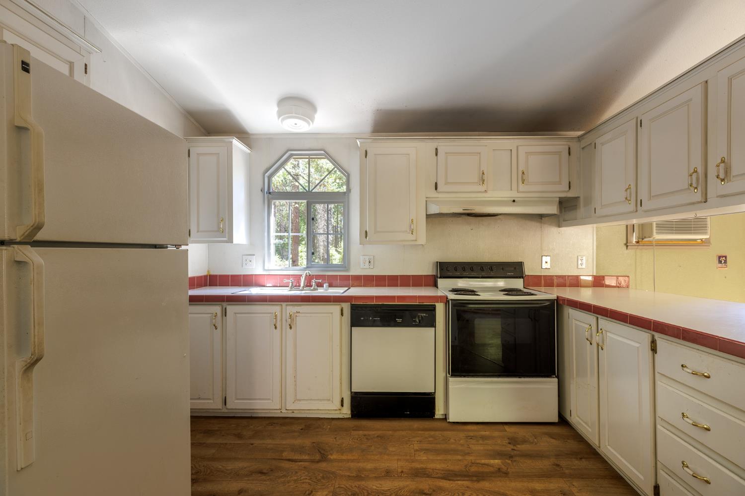 7140 Darling Cabin Road Garden Valley, CA 95633 - Photo 15 of 34 a kitchen with stainless steel appliances granite countertop a stove a sink and a refrigerator