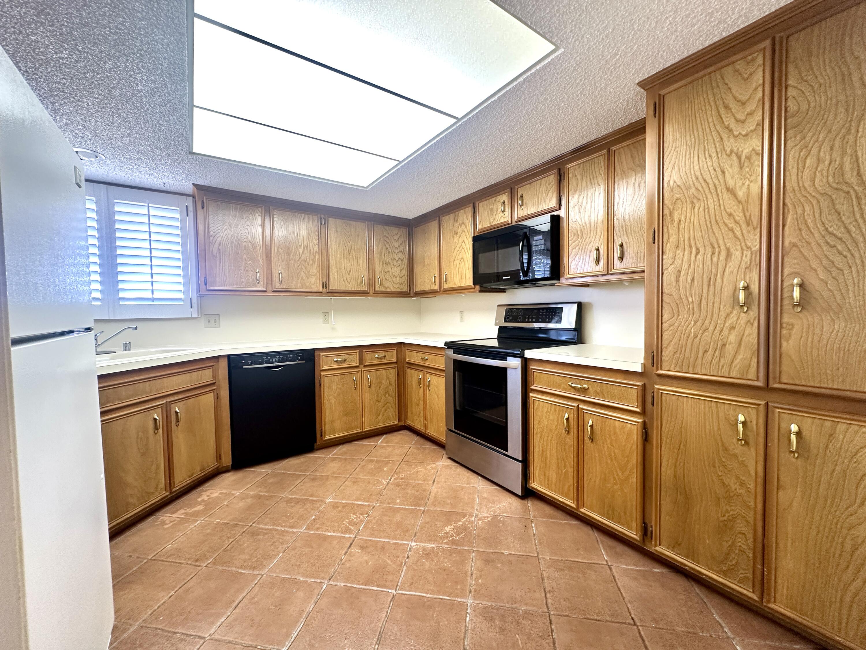 8614 Memphis Avenue, Unit B Lubbock, TX 79423 - Photo 4 of 11 a kitchen with stainless steel appliances granite countertop a stove a sink dishwasher a refrigerator and a microwave oven