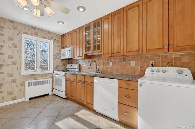 a utility room with cabinets washer and dryer