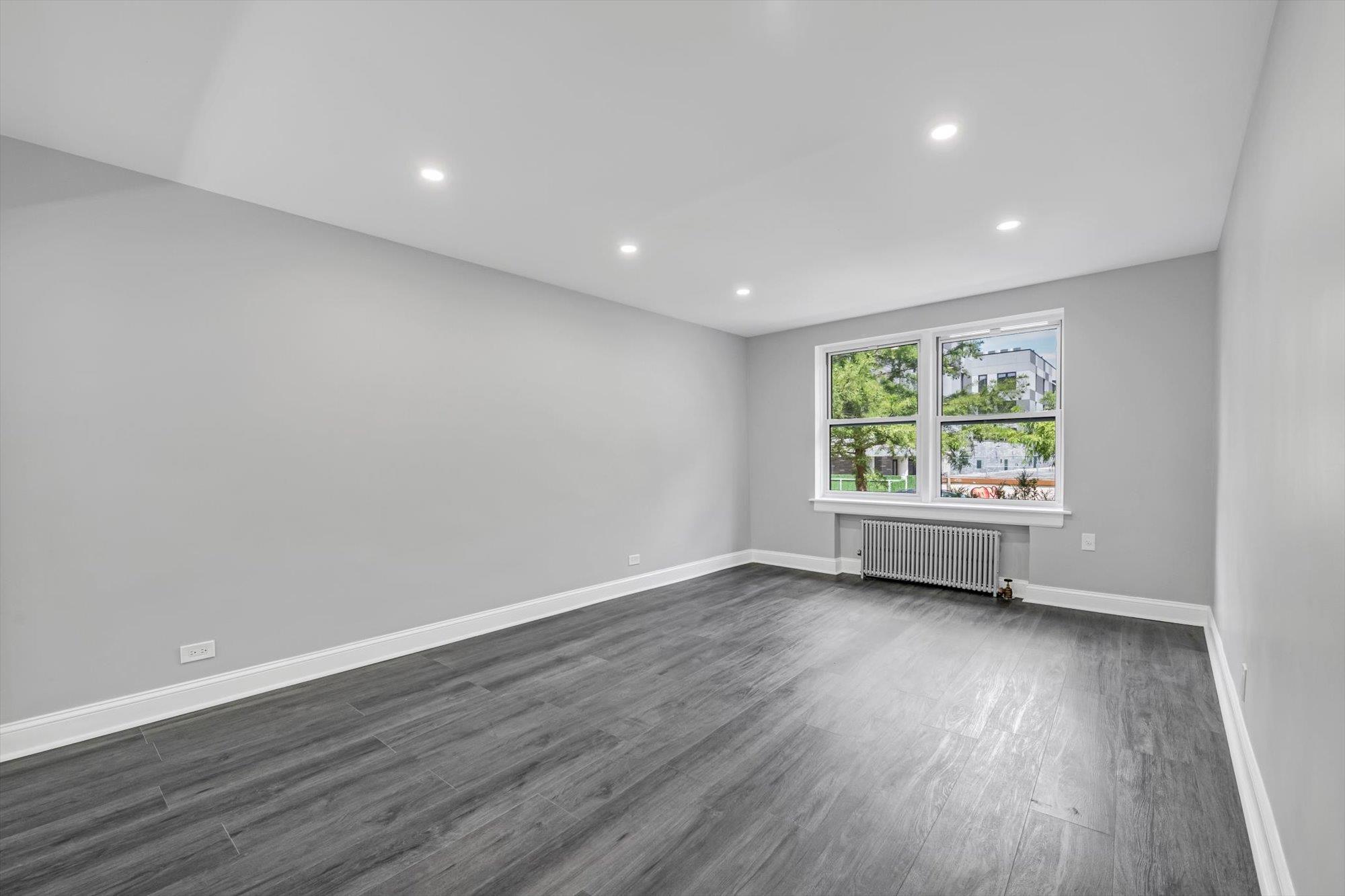 141-24 78th Avenue, Unit 1A Queens, NY 11367 - Photo 2 of 12 an empty room with wooden floor and window