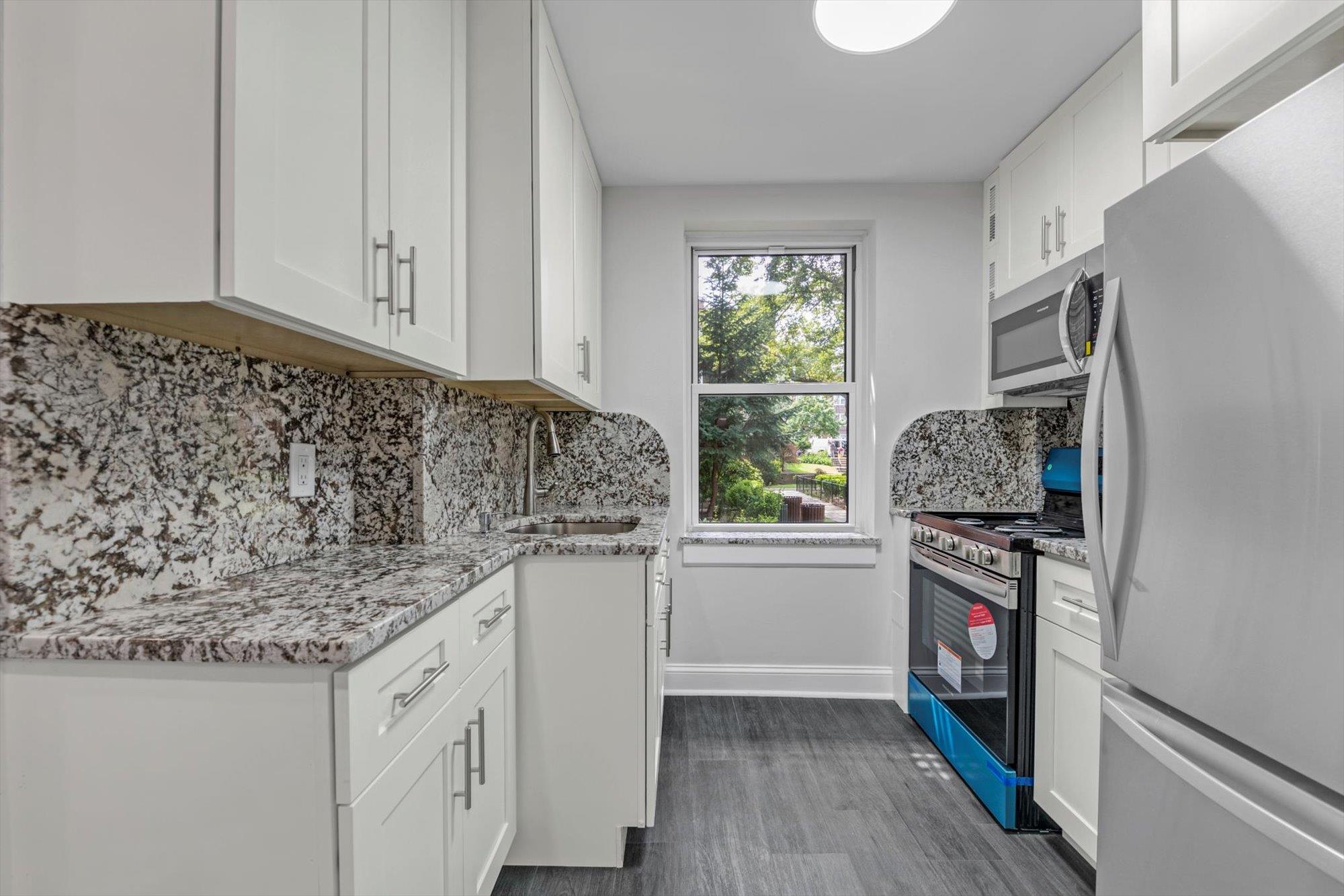 141-24 78th Avenue, Unit 1A Queens, NY 11367 - Photo 6 of 12 a kitchen with stainless steel appliances granite countertop a stove and a refrigerator
