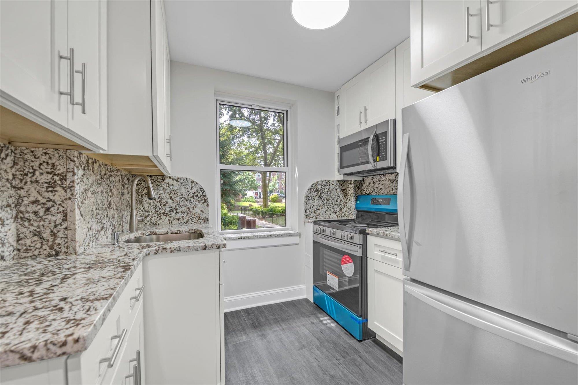 141-24 78th Avenue, Unit 1A Queens, NY 11367 - Photo 7 of 12 a kitchen with stainless steel appliances granite countertop a refrigerator sink and stove