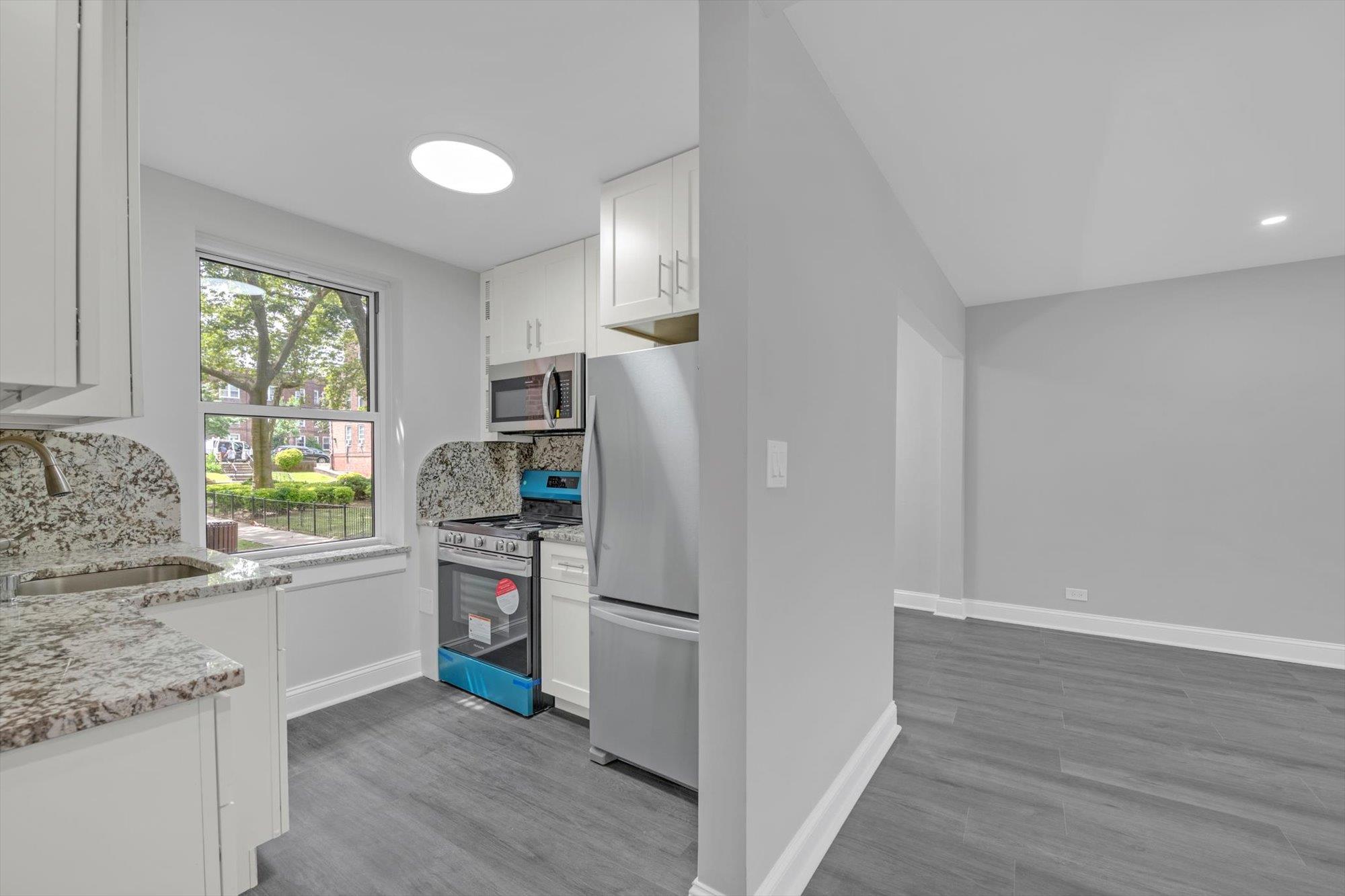 141-24 78th Avenue, Unit 1A Queens, NY 11367 - Photo 8 of 12 a kitchen with a refrigerator and a stove top oven