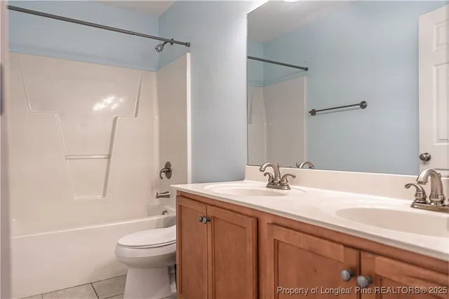 an empty room with chandelier fan and windows