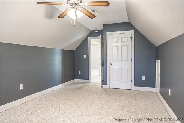 a view of a house with a yard and wooden fence
