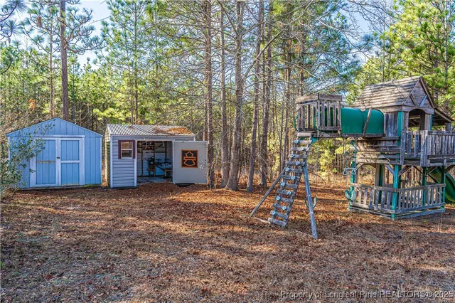 a view of a house with backyard and trees