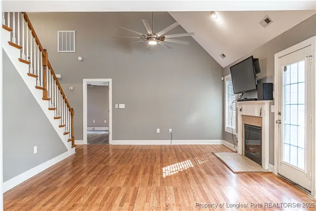 a view of a livingroom with wooden floor and a ceiling fan
