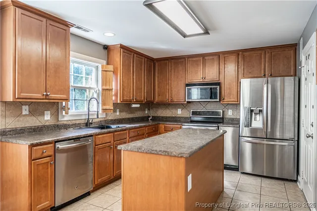 a kitchen with stainless steel appliances granite countertop a refrigerator and a sink