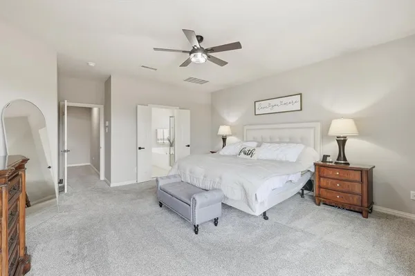 a bed room with a bed and a ceiling fan