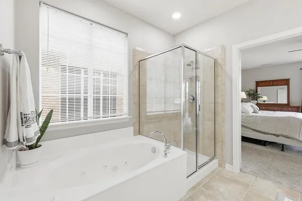 a en suite bathroom with a tub shower and window