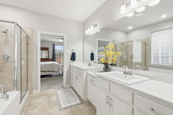 a en suite bathroom with a double vanity sink mirror and shower