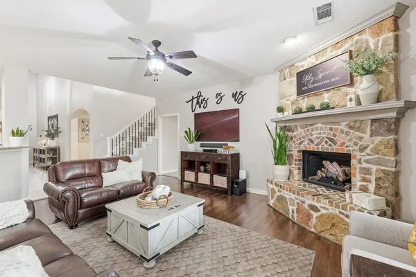 a living room with furniture a flat screen tv and a fireplace