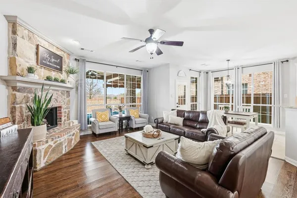 a living room with furniture large window and wooden floor