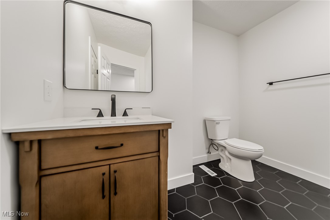 7488 Greenwich Road Seville, OH 44273 - Photo 16 of 37 Half bathroom with vanity and dark tile patterned flooring